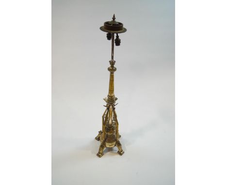 A 19th century plated brass altar type twin candlestick, adapted for electricity, with engraved and stylised plant and triang
