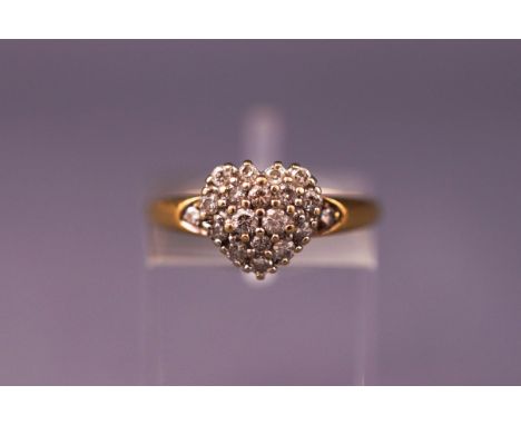 A yellow and white metal heart shape diamond cluster ring. Hallmarked 18ct gold. Size: K 1/2. Weight: 3.4 grams