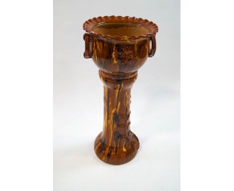 A late Victorian slipware jardiniere on stand, the planter with ring handles and crimped rim, the stand with tree and lady's 