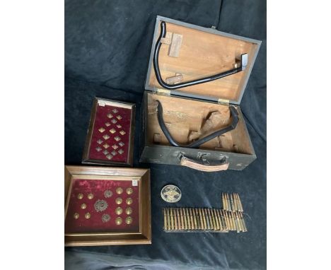 Two glazed cases containing buttons and badges with a wooden box containing ammunition (spent) and various casings.