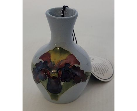 A boxed trial piece small Moorcroft vase, decorated in the Orchid blue light pattern , unmarked  9.5cm high x 6cm in diameter