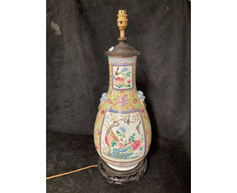 A 19th Century Cantonese enamel baluster vase, decorated with panels of exotic birds amongst foliage, beast mask ring handles