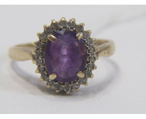 AMETHYST CLUSTER RING, large oval amethyst set in a cluster of diamonds, in 9ct yellow gold, size R/S 