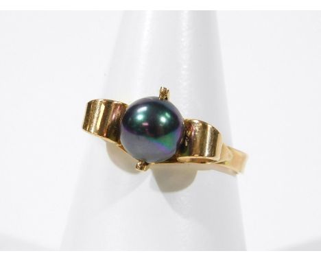 A cultured pearl dress ring, the ring set with purple coloured cultured pearl, with raised scroll shoulders, on a yellow meta