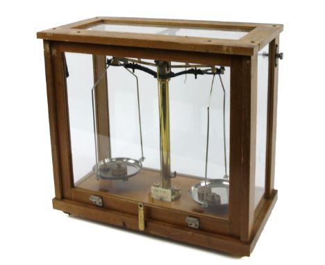 A mid 20thC scientific table scale, in four piece glazed case, with cylindrical brass centre and bass metal pans, 39cm H, 40c
