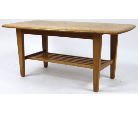 A mid 20thC Ercol style light elm finished coffee table, of shaped rectangular outline on shaped supports, 29cm H, 92cm W, 45