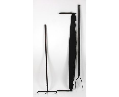 Bygone tools, comprising of an early 20thC three pronged hay fork, 28cm high, a Top Dog and Under Dog style saw and a pitch f