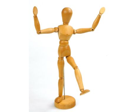 A light wood Studio style artist's figure sculpture, on a metal stem and circular base, with articulated limbs, 33cm high.