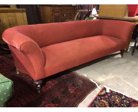 A late 19thc/early 20thc. sofa in a red wave pattern fabric upholstery, with curved back and arms, on turned front supports t