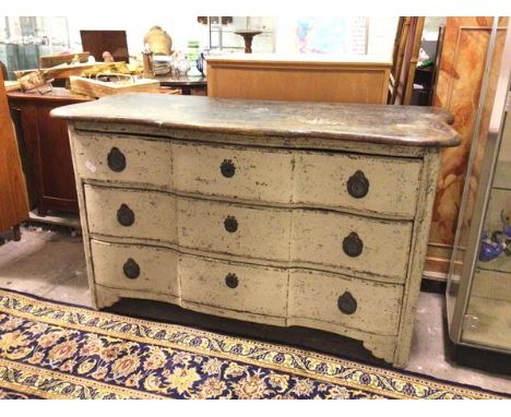 A distressed Continental commode of large proportions, the undulating top with rounded edge above three long drawers, on brac