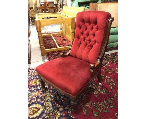 A late Victorian nursing chair with button back and curved sides, on turned front supports with castors (91cm x 64cm x 72cm)