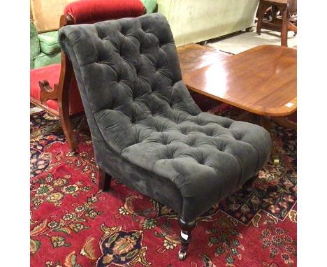 A modern slipper style chair with rolled top, button back and seat, on turned front supports terminating in castors (85cm x 6
