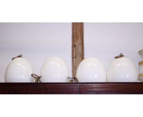 A set of four milk glass oviform ceiling light pendants, 12" high