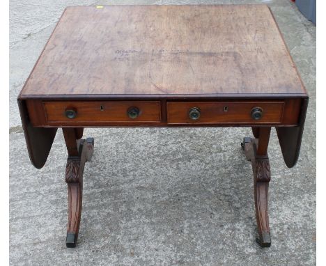 A Regency mahogany sofa table, on four acanthus leaf carved, reeded, splayed supports with brass casters, 32" wide