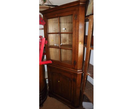 A well reproduced oak corner cupboard enclosed glazed panel door over cupboards, on bracket feet, 28" wide