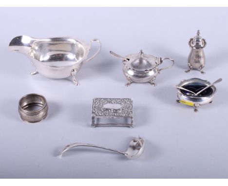 A silver sauce boat with ladle, a silver three-piece cruet set, a napkin ring, a matchbox holder, etc