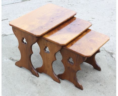 A nest of three burr elm top occasional tables, on panel end supports, 23" wide