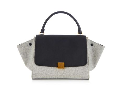 Celine, a Trapeze handbag, designed with a grey wool and smooth black leather exterior, featuring optional side wings, a rear