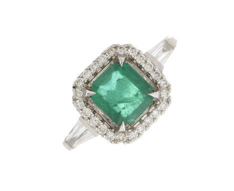 An 18ct gold emerald and brilliant-cut diamond cluster dress ring, with tapered baguette-cut diamond shoulders, emerald estim