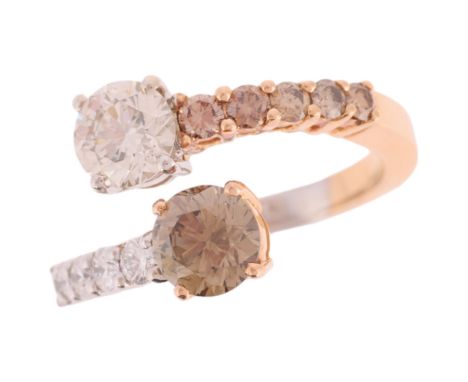 A Cognac Diamond and Diamond Crossover Ring,the terminals set with a modern round brilliant cut diamond, each weighing approx