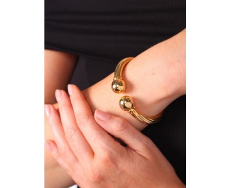 UNOAERRE - A Vintage Gold Bangle,each half of polished and twisted tubular form with a ball terminal and hinged central mecha