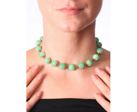 A Jadeite Jade Necklace,comprising one row of even sized jade beads measuring 13mm, interspaced with gold links and carved ja