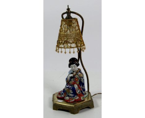 An attractive 19th Century Oriental brass and porcelain Table Lamp, modelled as a young Chinese Girl seated in typical attire