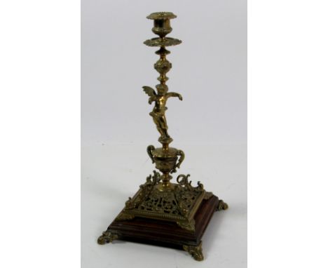 A tall elaborate Table Candlestick, with cupids support, and pierced base on wooden stand with scroll feet, approx. 39cms (15