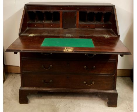 A Georgian period mahogany Bureau Chest, the crossbanded slope front opening to reveal a fitted interior over two short and t
