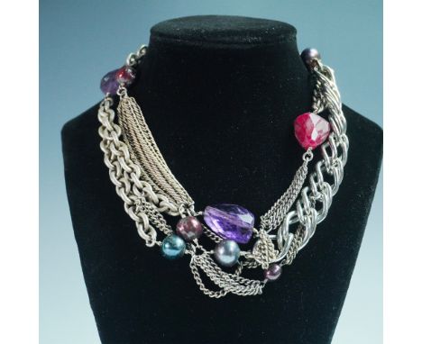 A striking multi-strand statement necklace featuring a mix of silver-tone and gold-tone chain links adorned with faceted gems