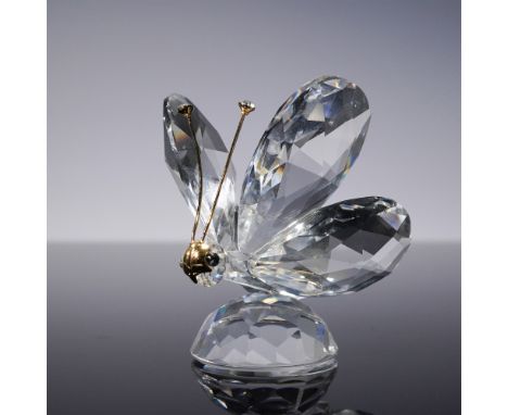 A stunning Swarovski crystal butterfly figurine, featuring elegantly faceted clear crystal wings and a delicate gold-tone met