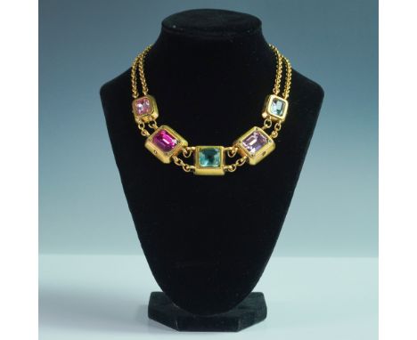 A striking gold-tone statement necklace featuring square-cut, faceted glass stones in vibrant jewel tones of pink, blue, and 