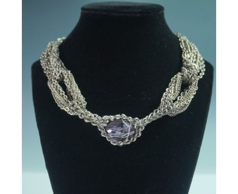 A bold multi-strand 18"L silver tone necklace featuring an intricately caged faux amethyst pendant. The twisted chain design 