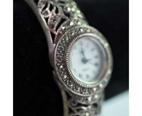 A beautifully crafted sterling silver marcasite bangle watch, showcasing intricate filigree floral detailing throughout its e