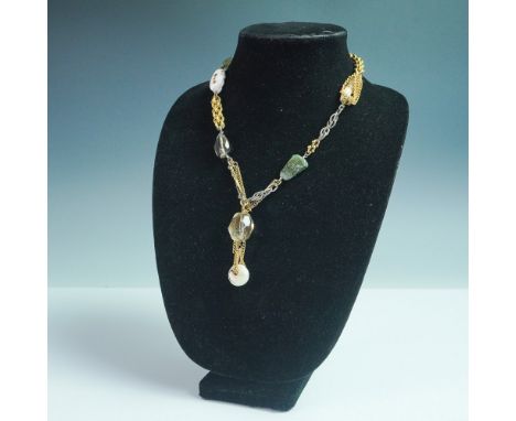 A distinctive 19-inch necklace featuring a mix of gold and silver-toned chains, adorned with an array of organic and faceted 