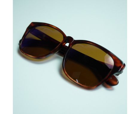 Revo sunglasses featuring polarized brown lenses set in a classic square frame with a warm brown mottled pattern. The right t