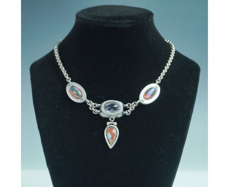 This striking silver-tone choker features an elegant design with bezel-set gemstones, including a central faceted oval stone 