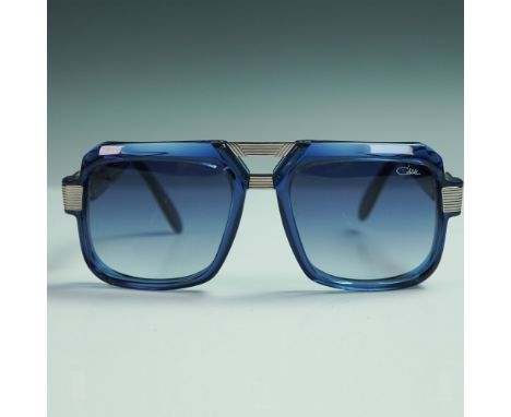 Striking pair of Cazal MOD 669 sunglasses featuring bold square frames in translucent blue with matching gradient lenses. The