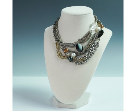 A bold and striking multi-strand choker necklace featuring an eclectic mix of silver and gold-toned chains accented with face