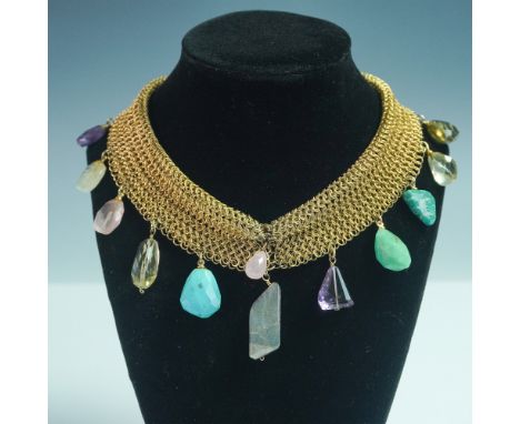 A striking gold-toned mesh choker featuring an array of faceted and raw-cut gemstone drops, adding vibrant color and texture.