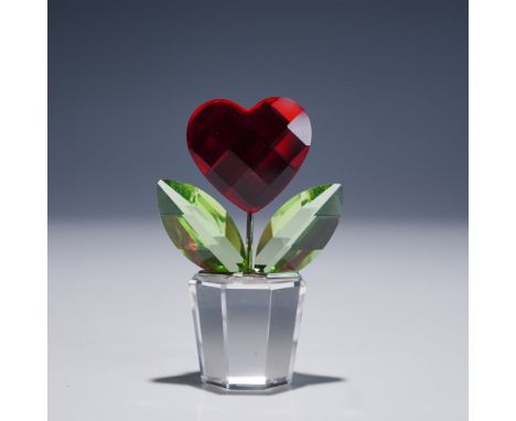 A charming Swarovski crystal figurine featuring a vibrant red faceted heart-shaped bloom, symbolizing love and admiration. Th