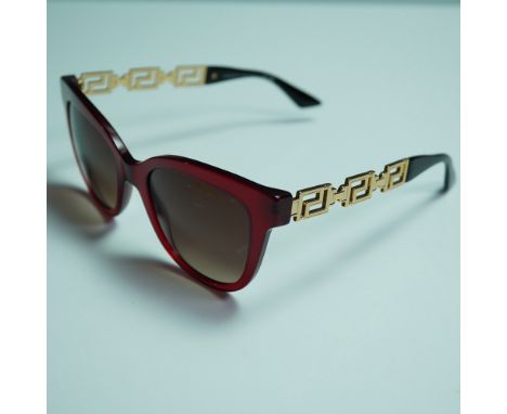 A pair of Versace model 4394 women's sunglasses featuring a striking red acetate frame with iconic gold-tone Greca-patterned 