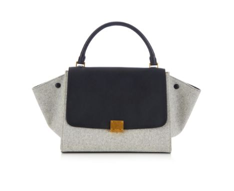 Celine, a Trapeze handbag, designed with a grey wool and smooth black leather exterior, featuring optional side wings, a rear