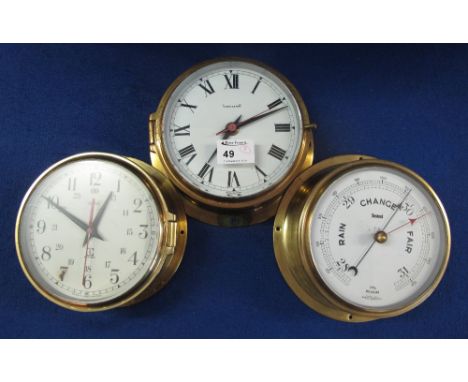 A Timemaster brass bulkhead clock with white enamel face, having Roman numerals and sweep second hand, a similar Smiths batte