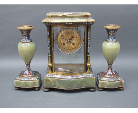 A French Mid XIX Century Onyx and Champléve Enamel Clock Garniture, the clock of serpentine form with shaped side columns, th