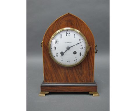 An Edwardian Mahogany Maple &amp; Co Mantle Clock, with brass handles and feet, the case with arched top, white enamel dial w
