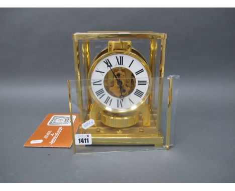 A Jaeger Le Coultre Atmos Clock, in brass and glass panelled case, the circular white enamel dial with black Roman numerals, 
