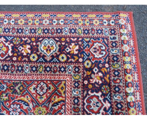 A LARGE CARPET - RUST / TERRACOTTA GROUND WITH NAVY / YELLOW PATTERN, APPROX 365 X 253 CM - WEAR THROUGHOUT