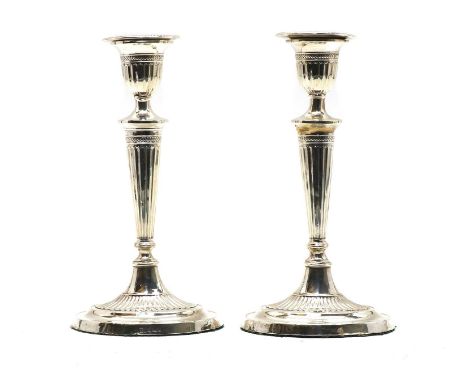 A pair of Adam revival silver candlesticks, with urn shaped sconces, tapering columns and on oval loaded bases, Sheffield 190