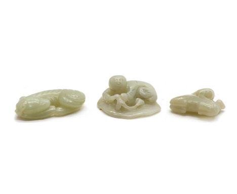 Three Chinese jade carvings, comprising: one of a boy, lying on his stomach on a lotus leaf, 4.2cm wide, a pendant, of a recu